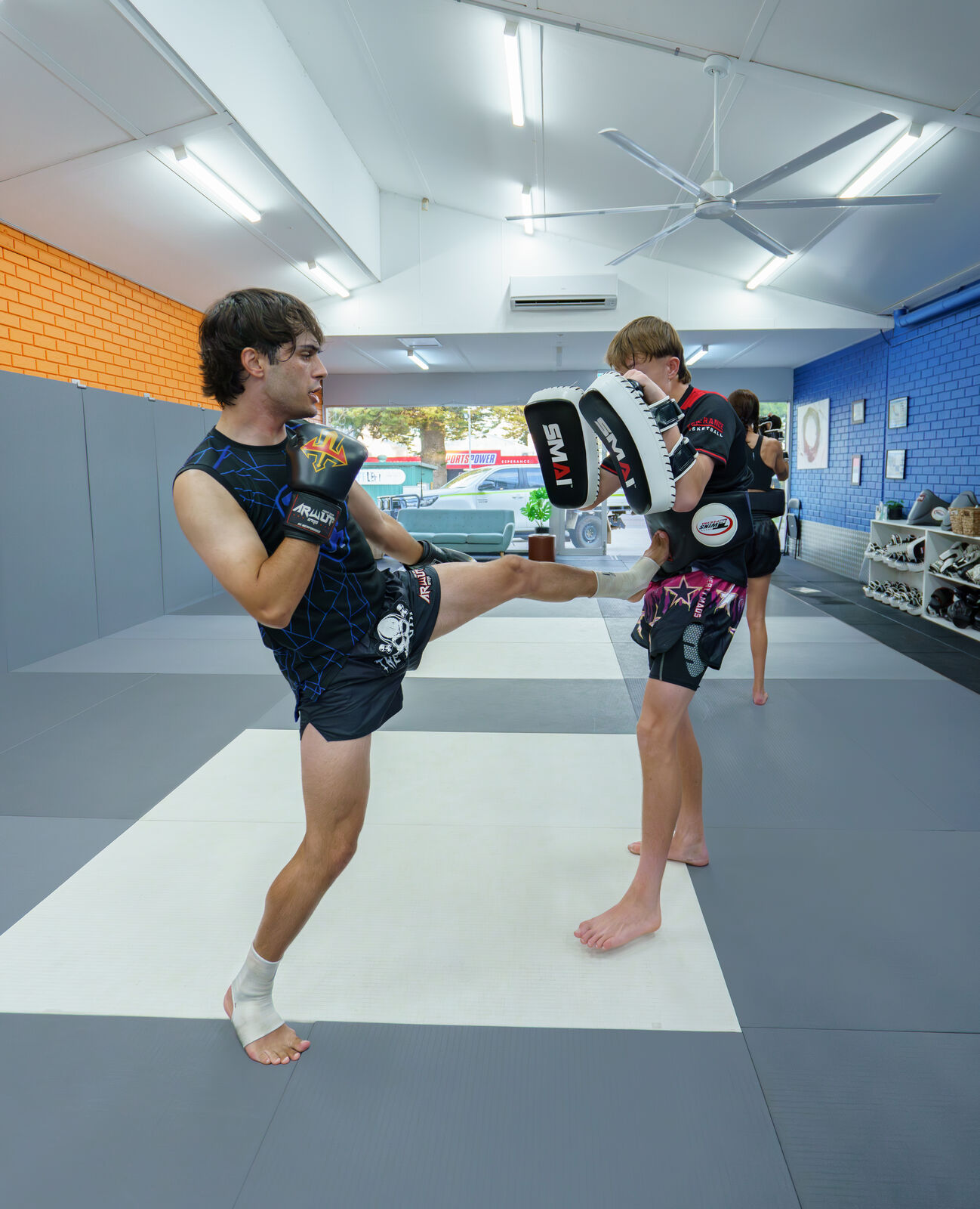 Teen holding pads for a high kick